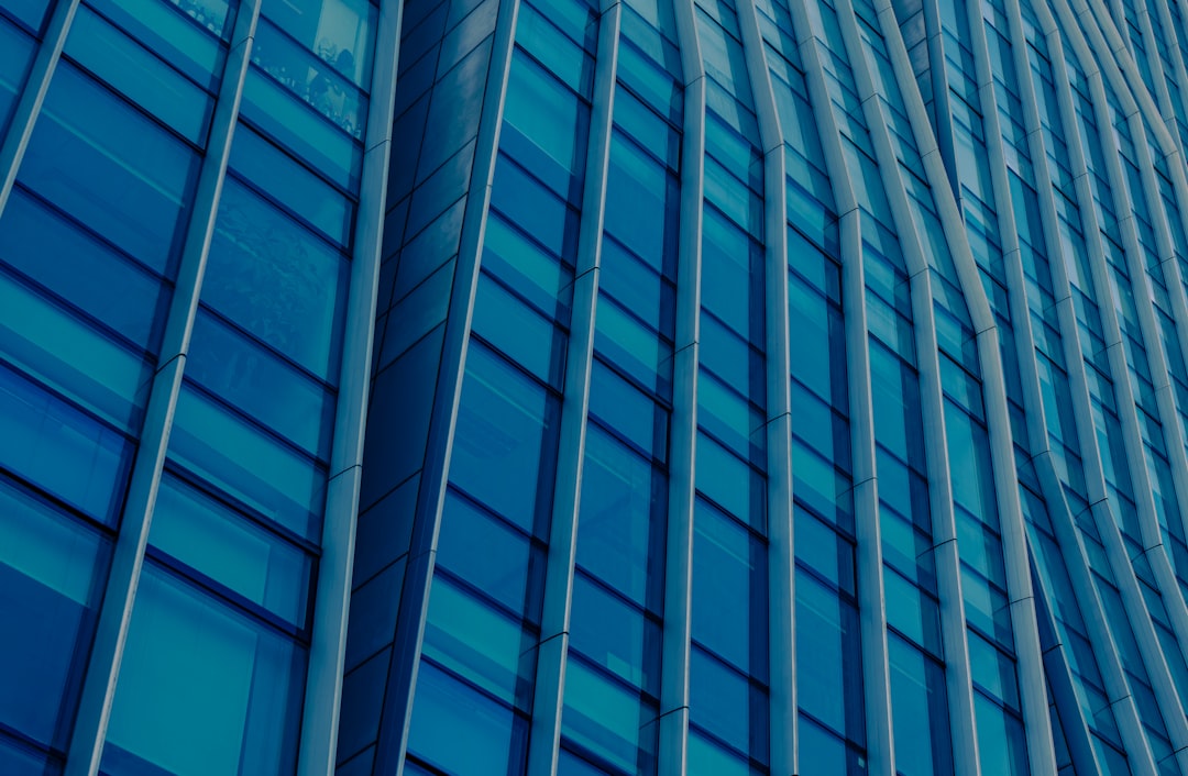 Modern blue glass skyscraper facade with vertical lines